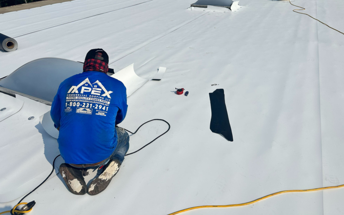 Apex Roofer Kneeling And Working On Roof