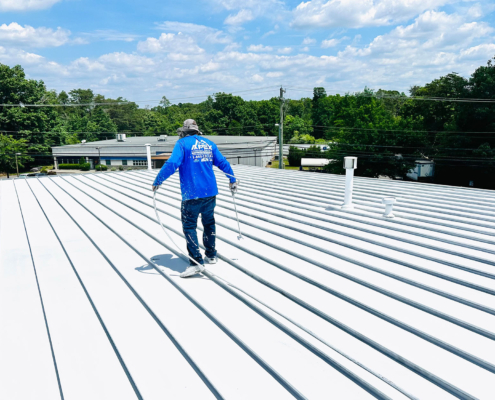 Single Roofer Walking On Flat Metal Roof