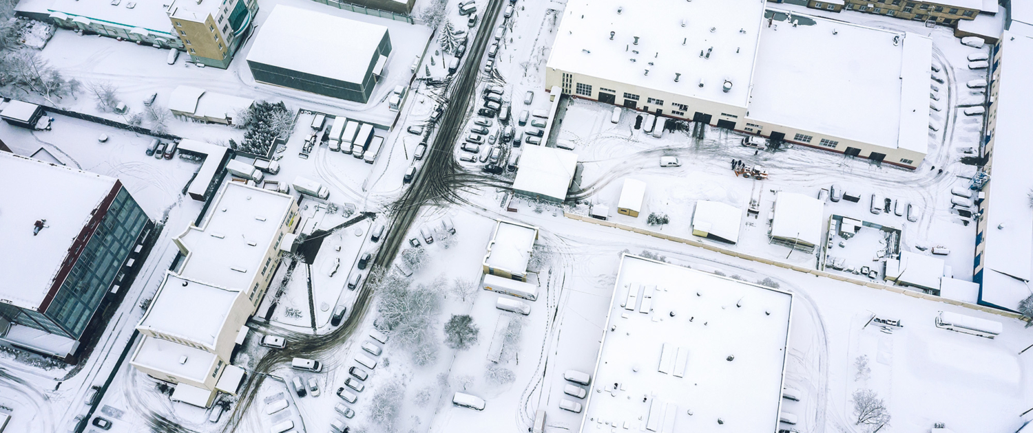 Flying Over The Industrial Area Of The City Covered By Snow On Foggy Winter Day